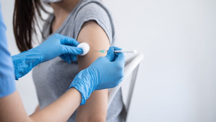 Hand,Of,Young,Woman,Nurse,,Doctor,Giving,Syringe,Vaccine,,Inject