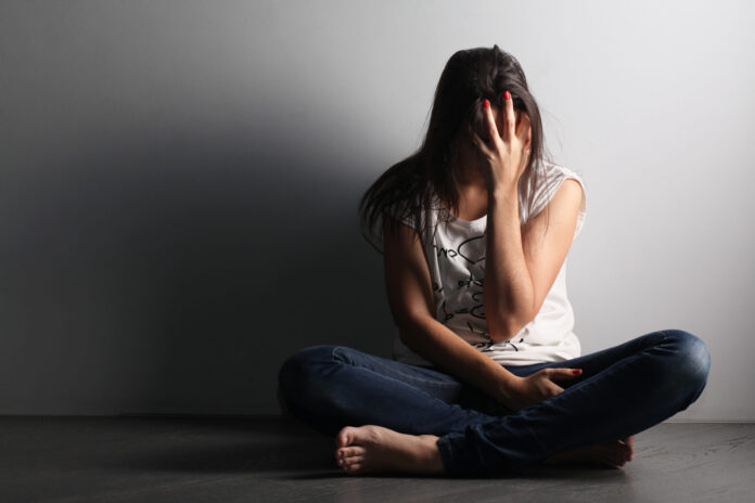 Teenager,Girl,With,Depression,Sitting,Alone,On,The,Floor,In